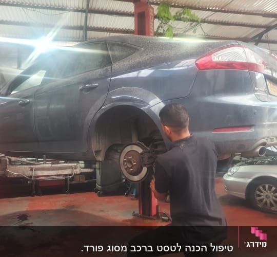 מכונאי עובד על רכב מורם במוסך